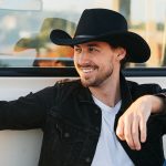 Man in Black Cowboy in back of truck by Peter Grimm