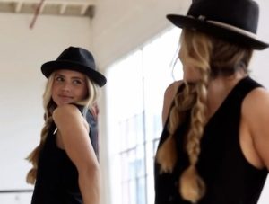 Women looking in mirror with black fedora hat